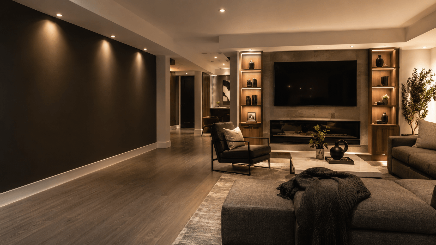 Dark finished basement media wall with warm lighting and lounge seating