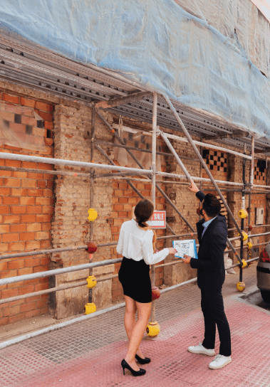 SS RENO LTD. team reviewing an exterior renovation project beside a home under construction